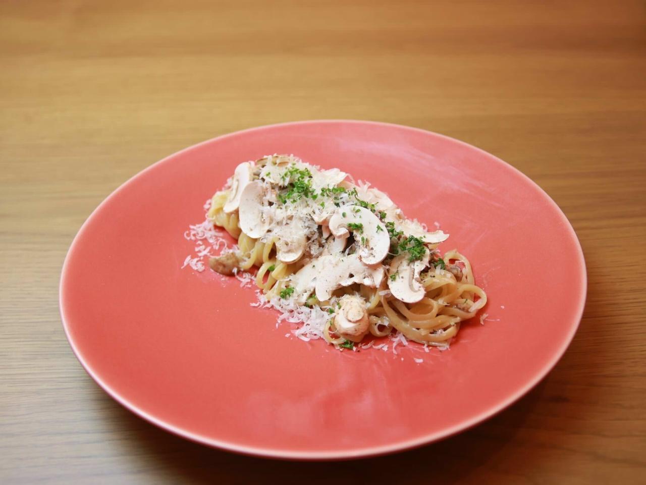 赤いプレートに盛られた牛窓産マッシュルームクリームパスタ
