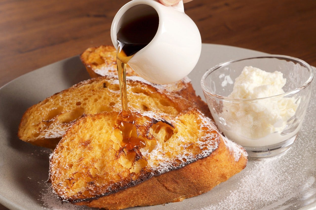 フレンチトーストにメープルをかけている様子
