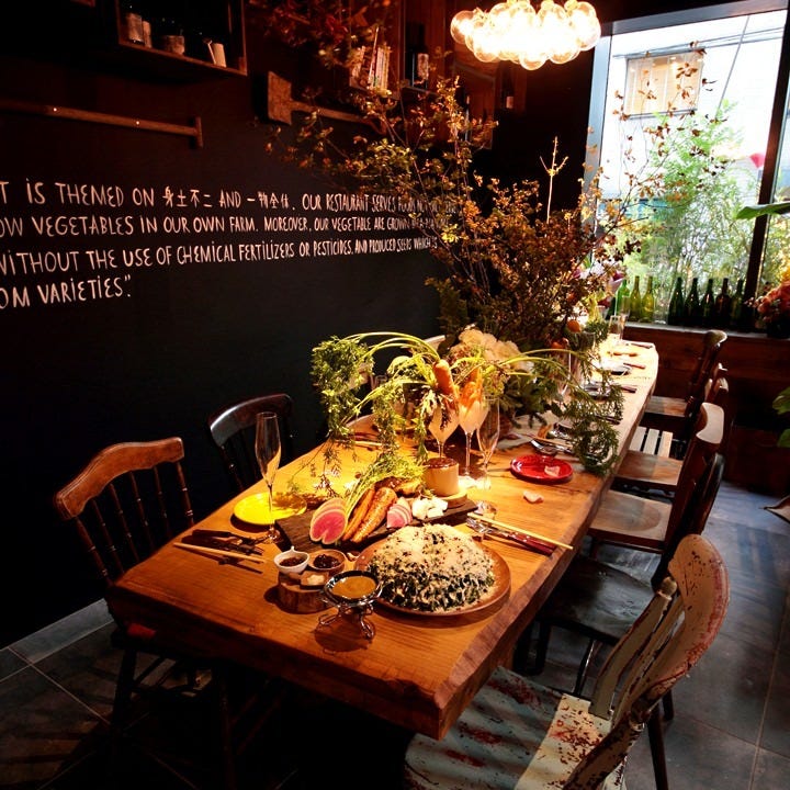 サラダやグラスが置かれた木のテーブルがおしゃれな内観