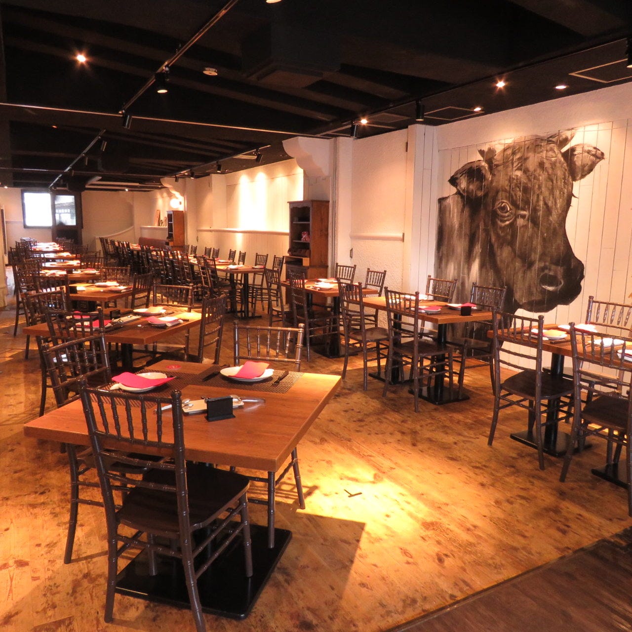 木を基調として壁に牛のイラストが描かれたアレグリア タチカワの店内