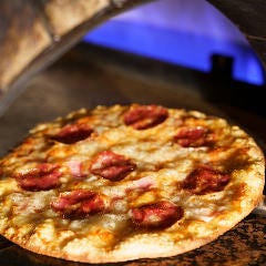高温の石窯で焼き上げるピッツァ。ピザ生地にはビール酵母を使用