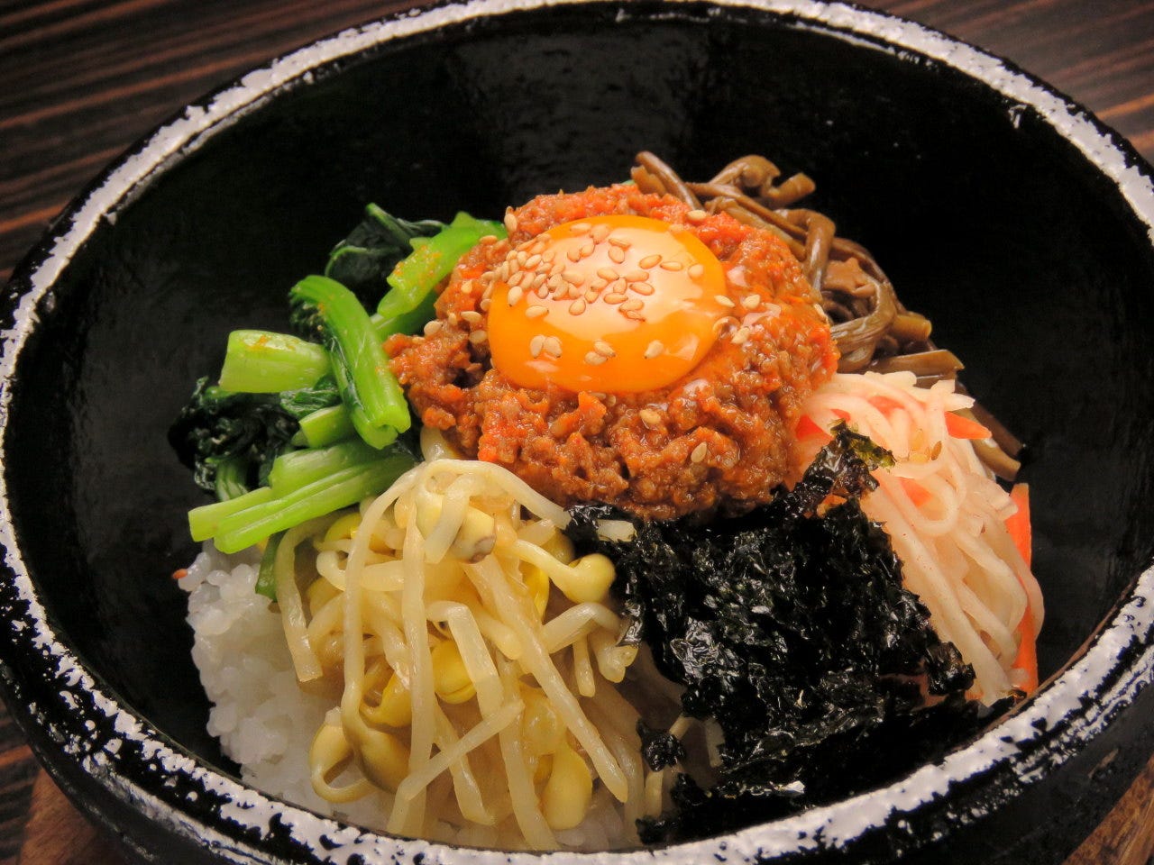 もやしや小松菜など5種類の具材に、お肉と卵黄がのった石焼ビビンバ