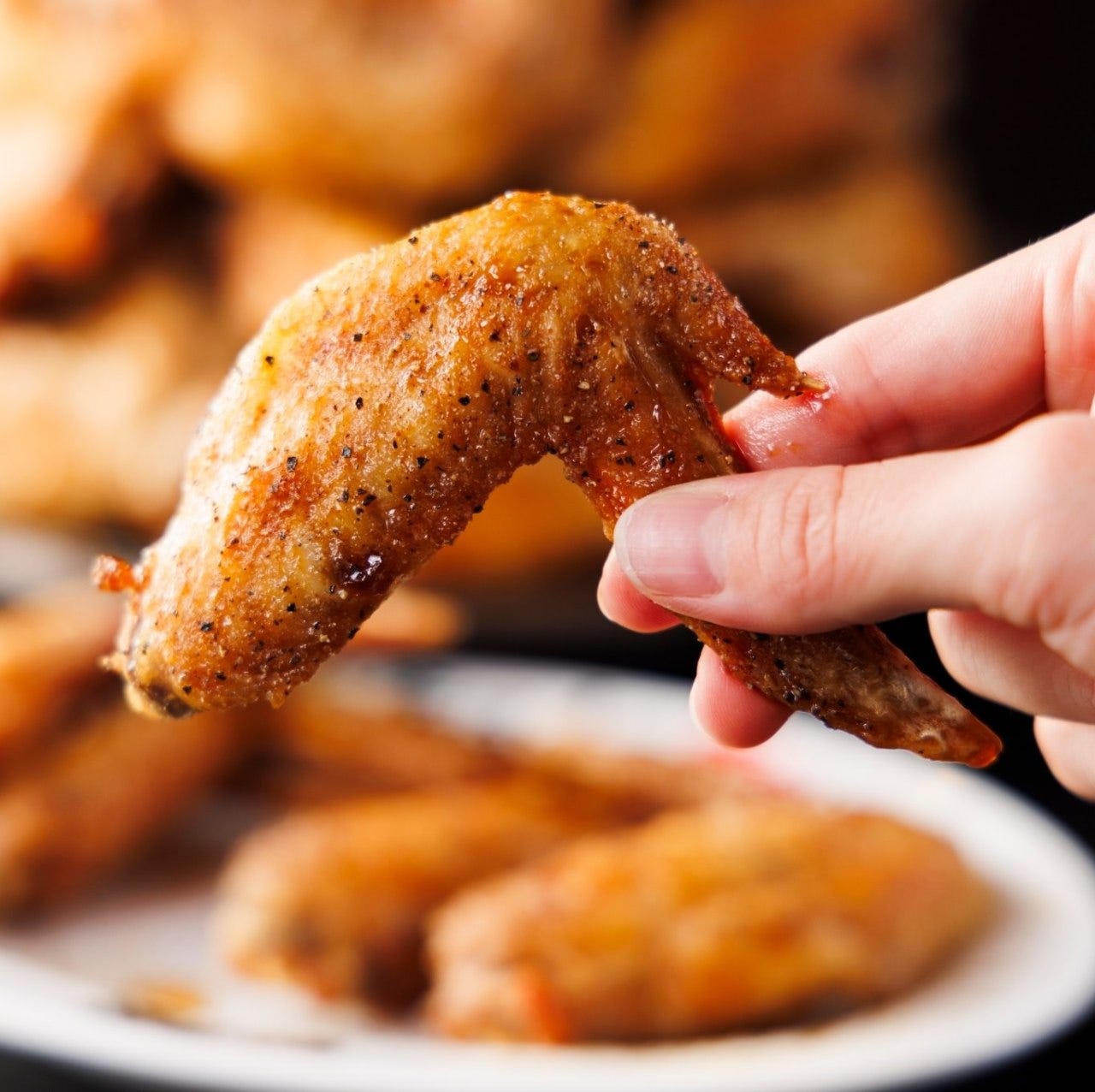 スパイシーな衣の手羽先を持っている様子