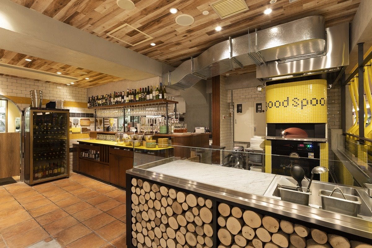 黄色の石釜が印象的な「グッドスプーンピッツェリアアンドチーズ 横浜モアーズ店」の外観