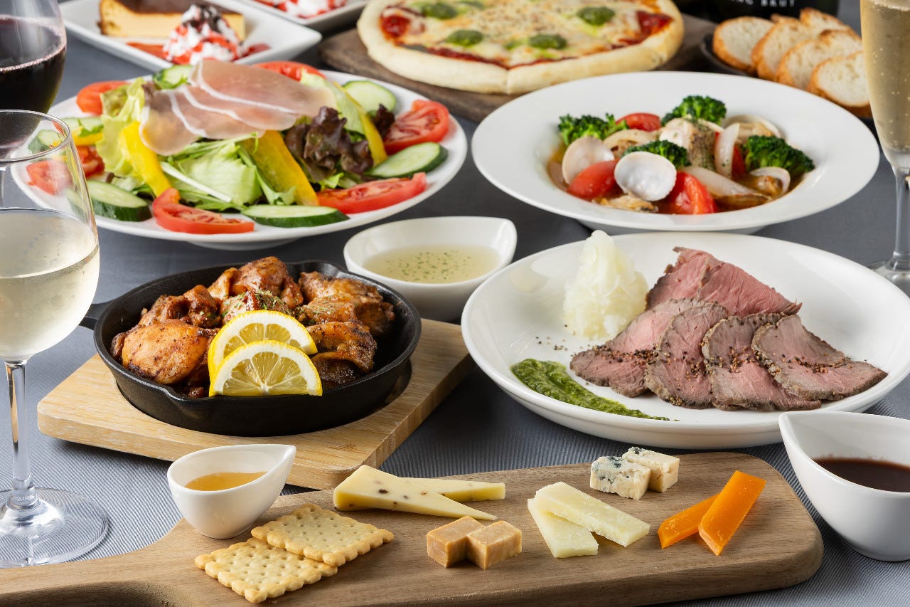 ローストビーフやサラダ、チーズの盛り合わせやピザなどが並ぶテーブル