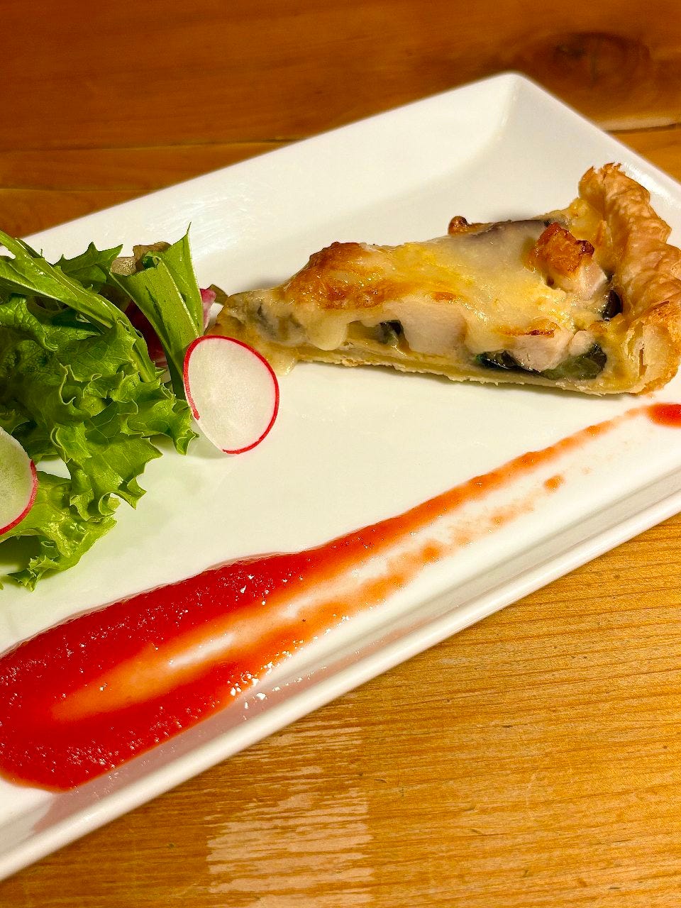 野菜とキッシュが盛りつけられた今月のランチコースの前菜メニュー