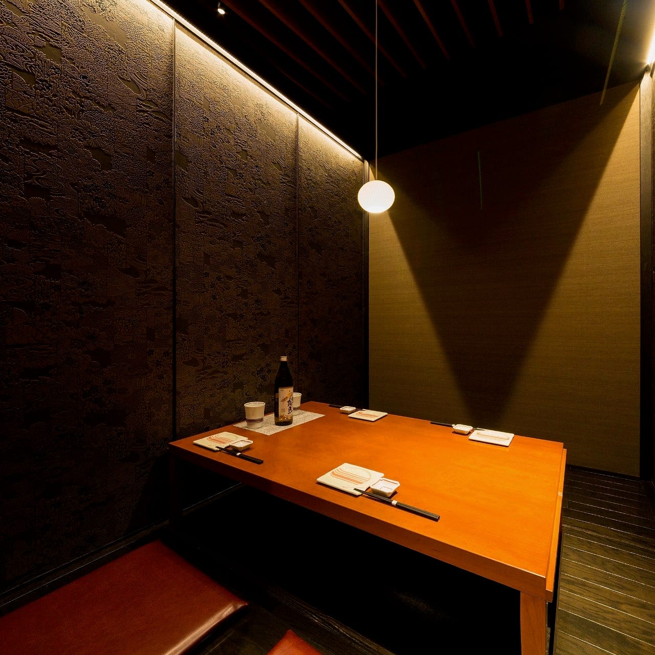 黒い壁に穏やかな照明が高級感を演出する、扉付きの完全個室