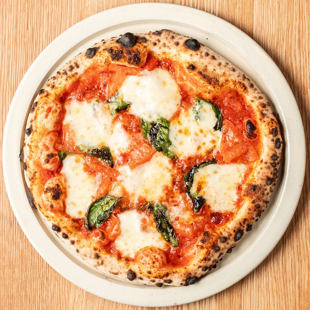 白い皿にのったマルゲリータピッツァ