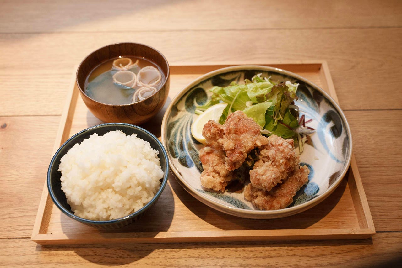 木のおぼんにのった味噌汁とご飯と唐揚げ