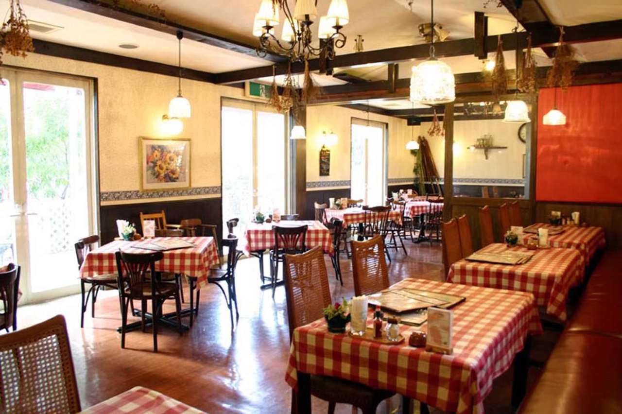 赤チェックのテーブルクロスがひかれたテーブルが並ぶ店内