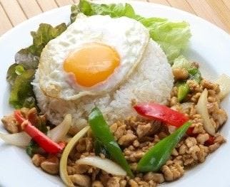 目玉焼きがのったタイガーデン 渋谷店のガパオライスがテーブルの上に置かれている様子