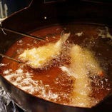 食材に合わせて油の温度や衣のつけ方を絶妙に調整していく。油を垂らし1部分だけ温度を下げるなど全て1つの鍋の中で行います。