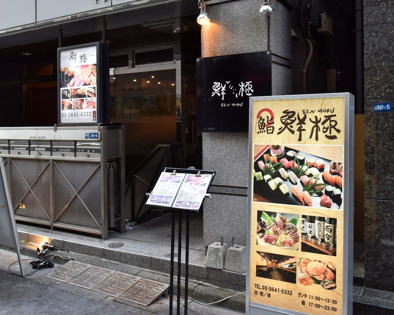 グレーを基調とした建物と寿司の写真の立て看板