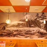 テーブル席横にある大きな富士山の壁画はなんと当店の為にデザイナー&イラストレーターさんが手書き！