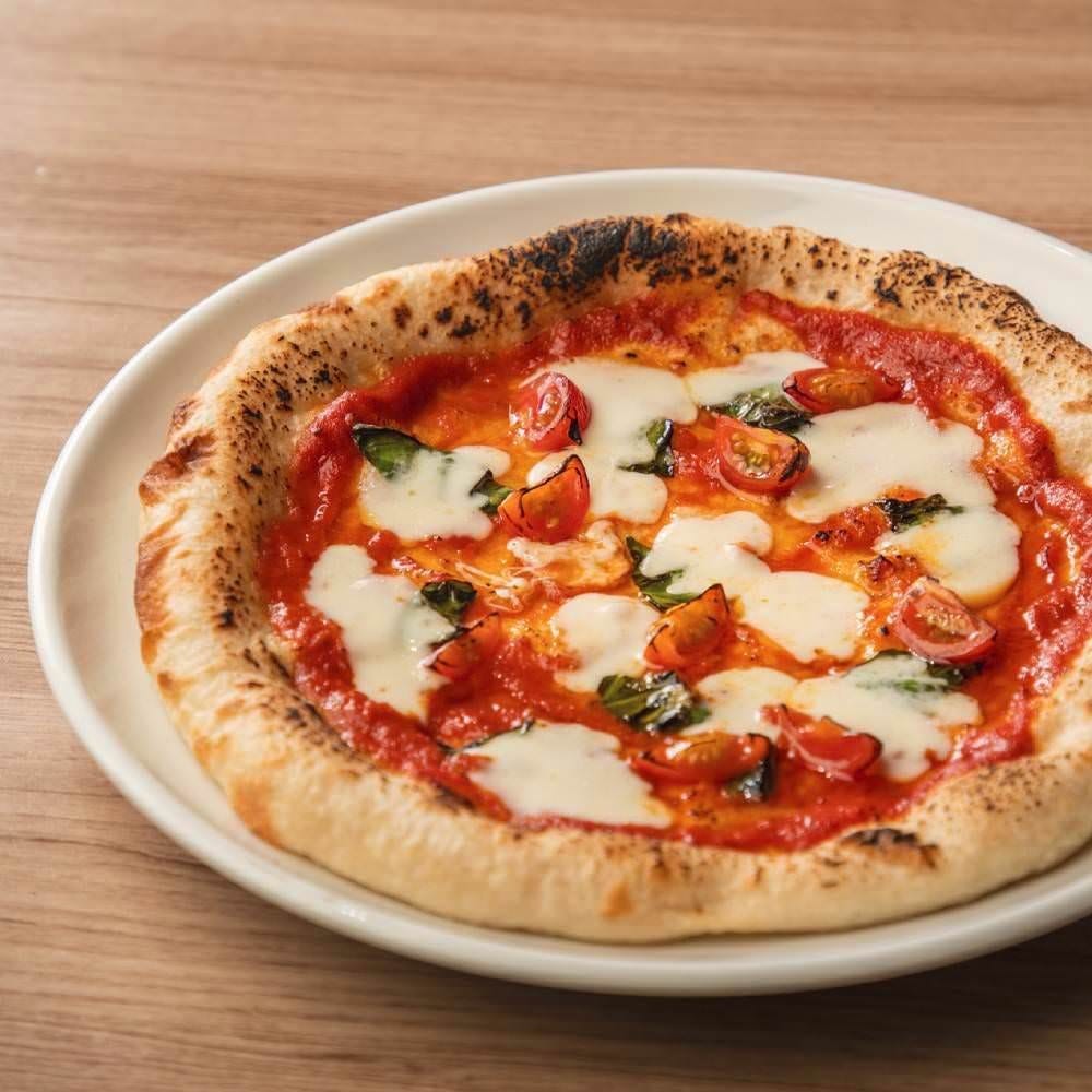 丸く白い皿で提供されるマルゲリータ