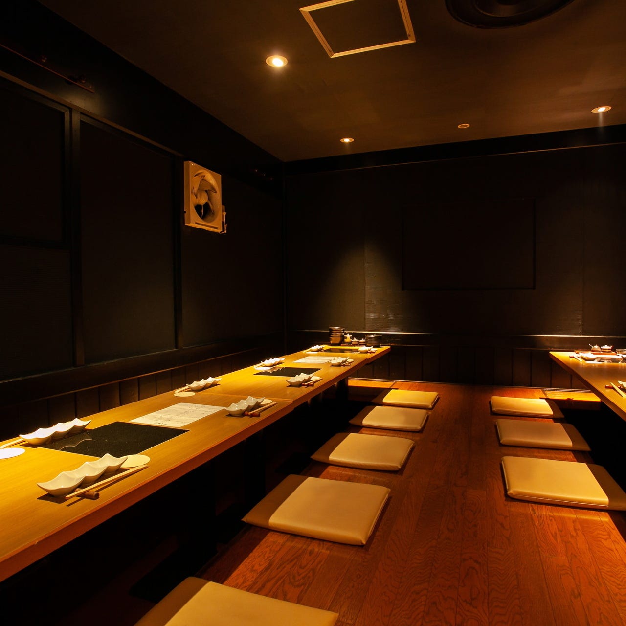 落ち着いた照明に座布団とテーブルが並ぶ座敷席