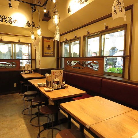 和テイストのテーブル席が並んでいる肉汁餃子のダンダダン 立川北口店の店内の様子