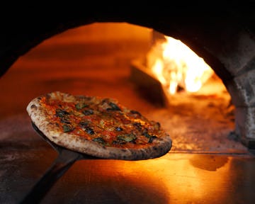 窯でピザを焼いている様子