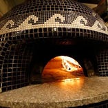 ピッツァは薪窯で丁寧に焼き上げます。