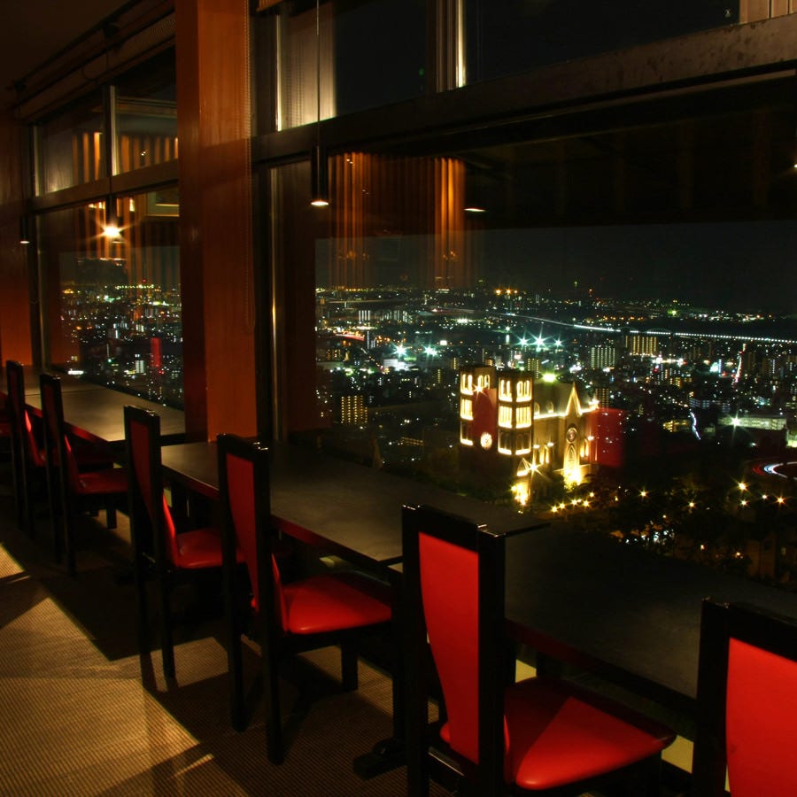 ガラス窓に面したテーブル席。市内の夜景を一望できます。