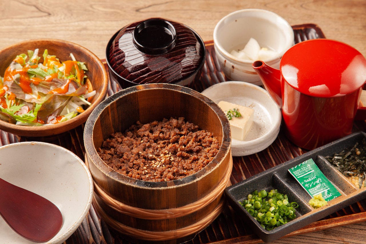 木のお盆に並んだ時雨煮ひつまぶしやサラダ、小鉢など