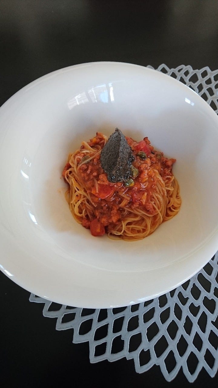 白いお皿に盛り付けられたトマトソースのパスタ