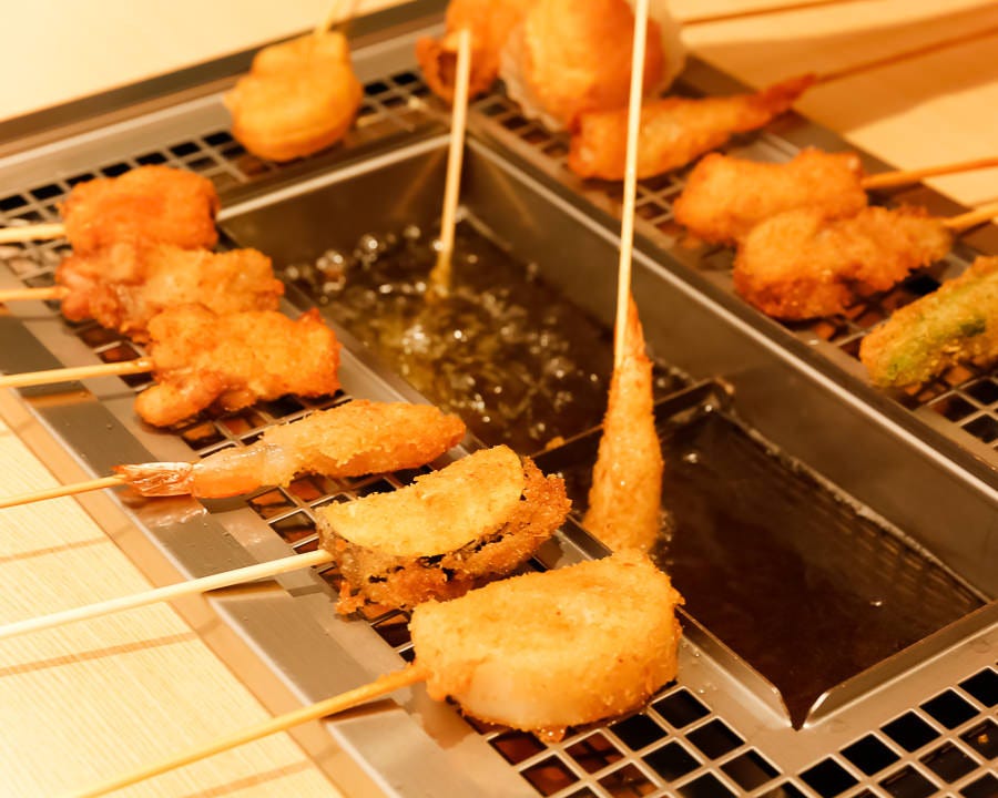 並んでいる串揚げと揚げている串揚げ