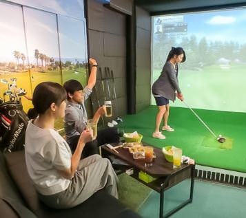 上野で完全個室でゴルフが楽しめるリアルゴルフの室内。空模様の壁に芝生が映える