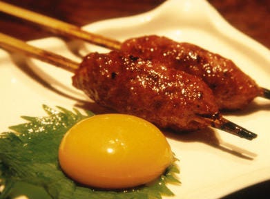 生つくね元屋 北千住店の生つくねに卵黄が添えられた月見生つくね