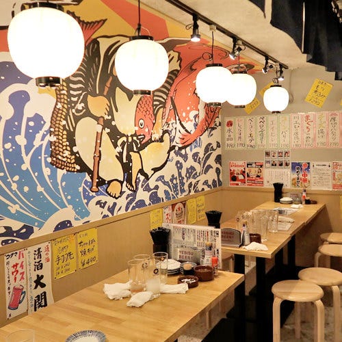 縁起のよいイラストが描かれた店内のテーブル席