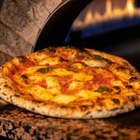 自家製生地のピッツァは専用の石窯に入れ、高温で一気に焼き上げます
