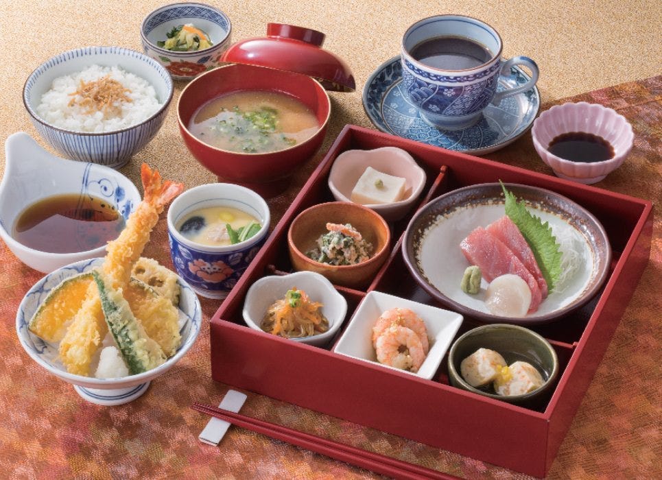 小鉢が詰められたお重や天ぷらなどが並んだお昼の彩り弁当