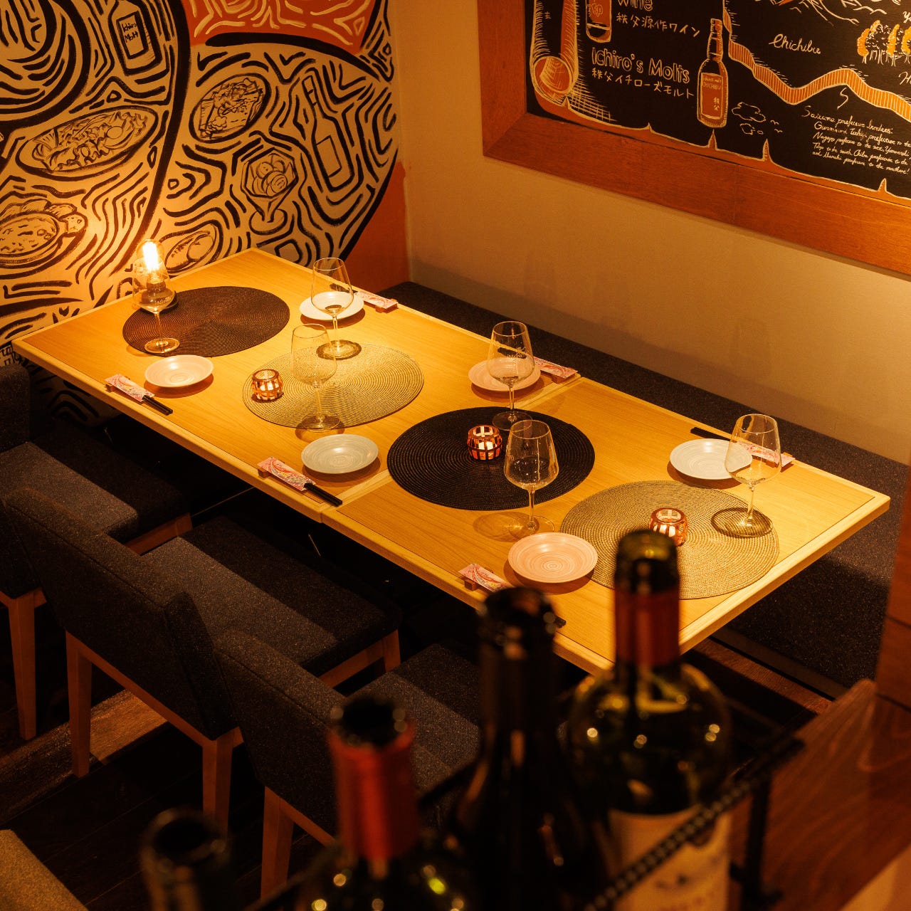 おしゃれな絵が描かれた壁沿いのテーブル席が並んでいるハラミちゃん 大宮西口店の店内