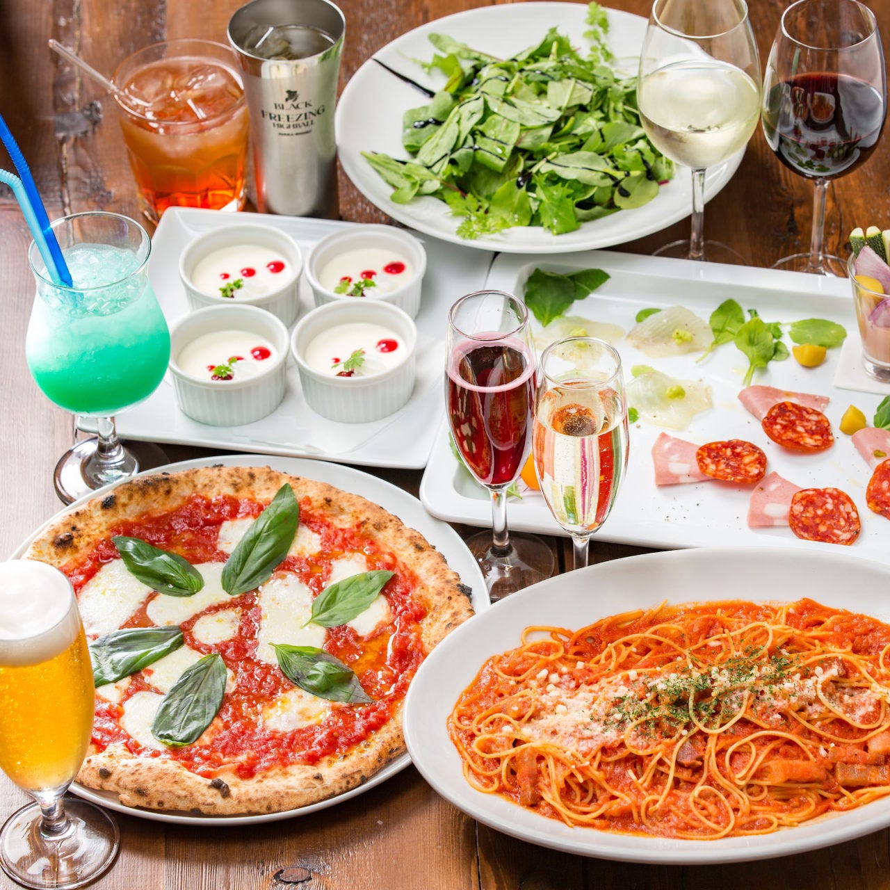 ピザやパスタ、前菜やドリンクが並ぶテーブル