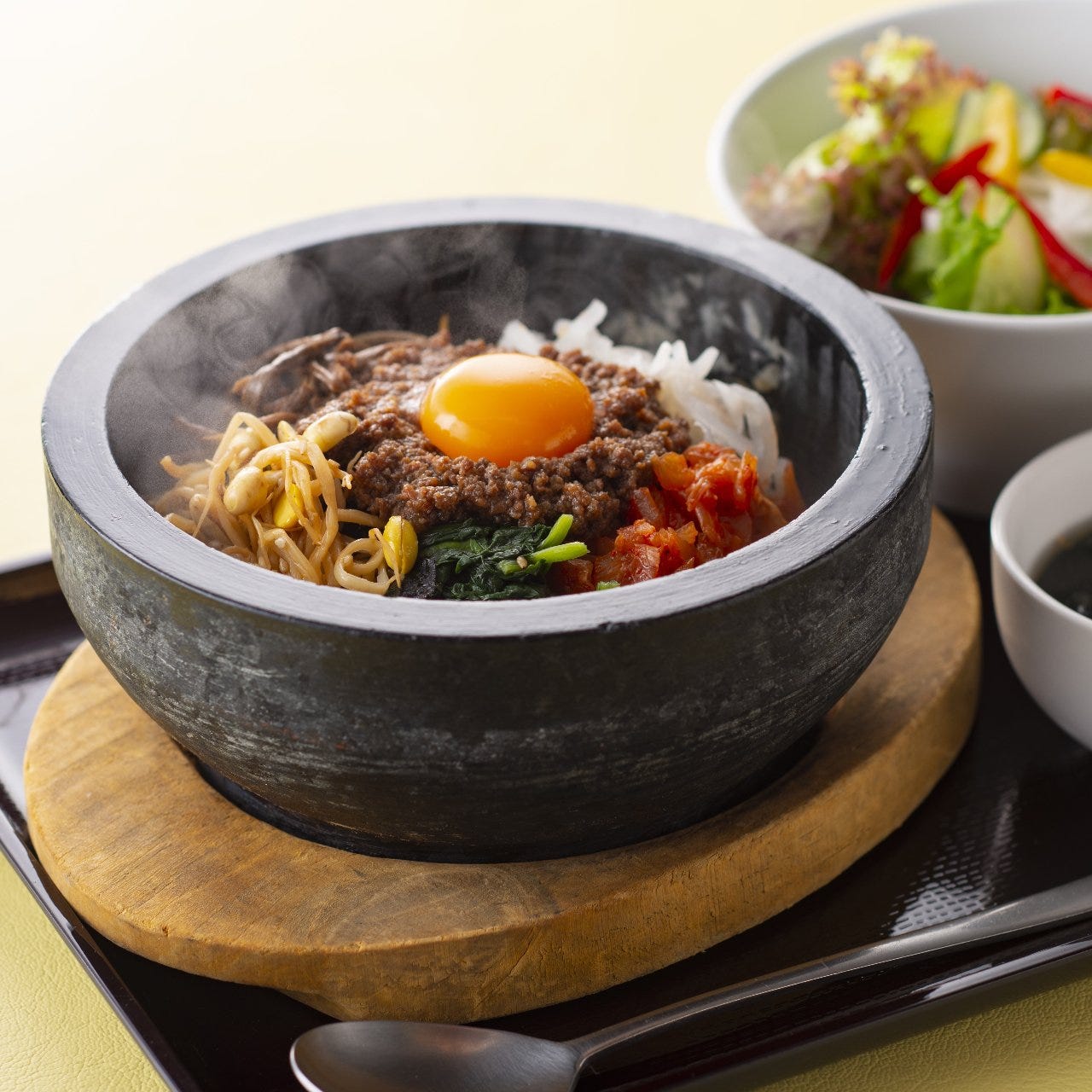 博多焼肉 ヌルボンの石焼ビビンバやサラダが置かれている様子