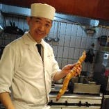 自分で掘った自然薯（じねんじょ）を手にニッコリの店長。天ぷらに揚げたり、拍子木切りにしてお出しします。