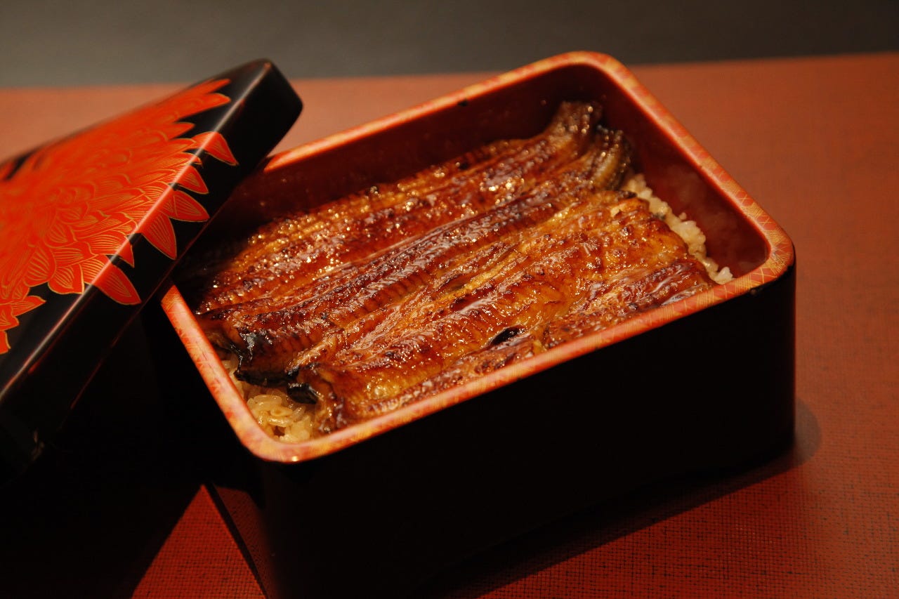 赤いテーブルにのっているわたべのうな重