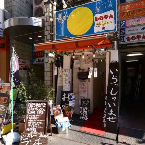青と黄色のファサード看板が目を引くもうやんカレーの外観