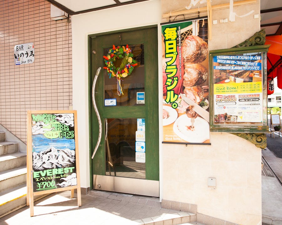 緑のドアにリースが飾られた「シュハスカリア キボン 浅草店」の外観