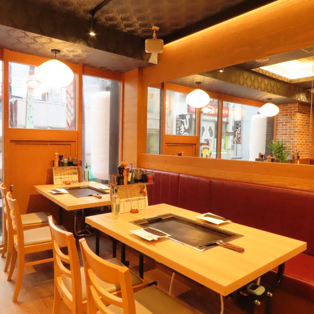 明るい照明でカジュアルな空間、赤いソファーシートがおしゃれな月島もんじゃ三九の半個室