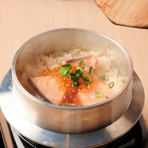 釜飯に盛られたご飯といくらと鮭