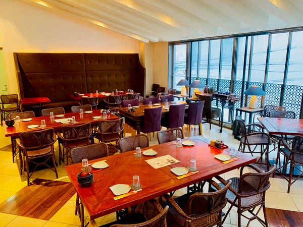 濃いブラウンのテーブルと椅子が並んだ店内