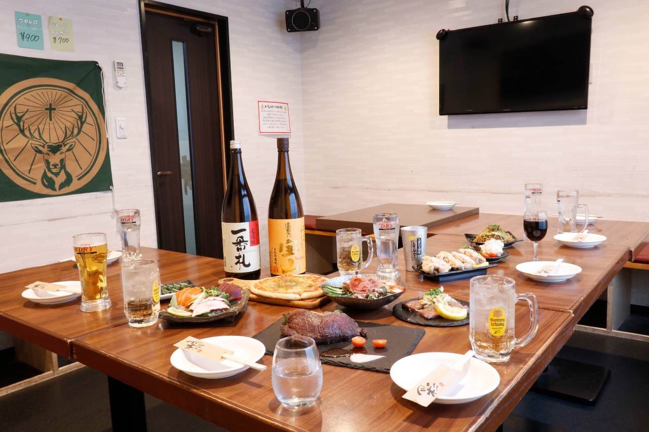 料理やお酒などがテーブルセッティングされているテーブル席が並んだ酔り道 大宮総本店の店内