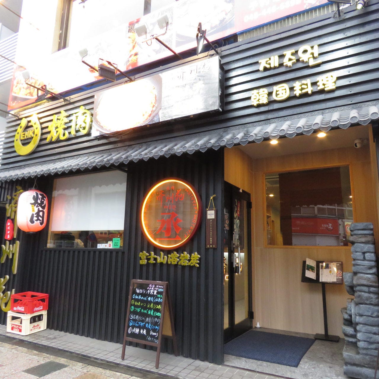 黒い壁面の店頭にメニューの看板が置いてある「焼肉 済州苑 西川口店」の外観