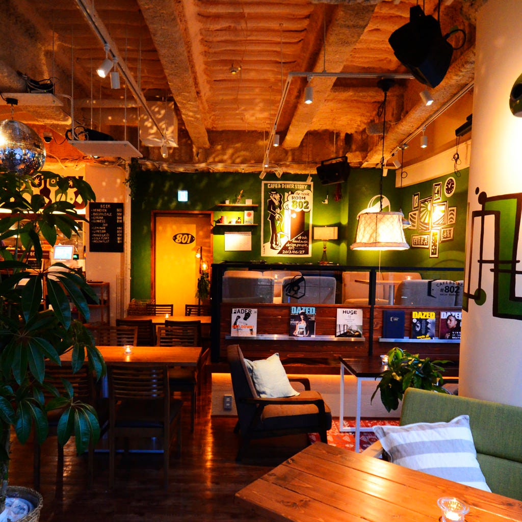 観葉植物や雑誌などがおかれたナンバー ハチマルニ カフェ アンド ダイナー シブヤテンの店内の様子