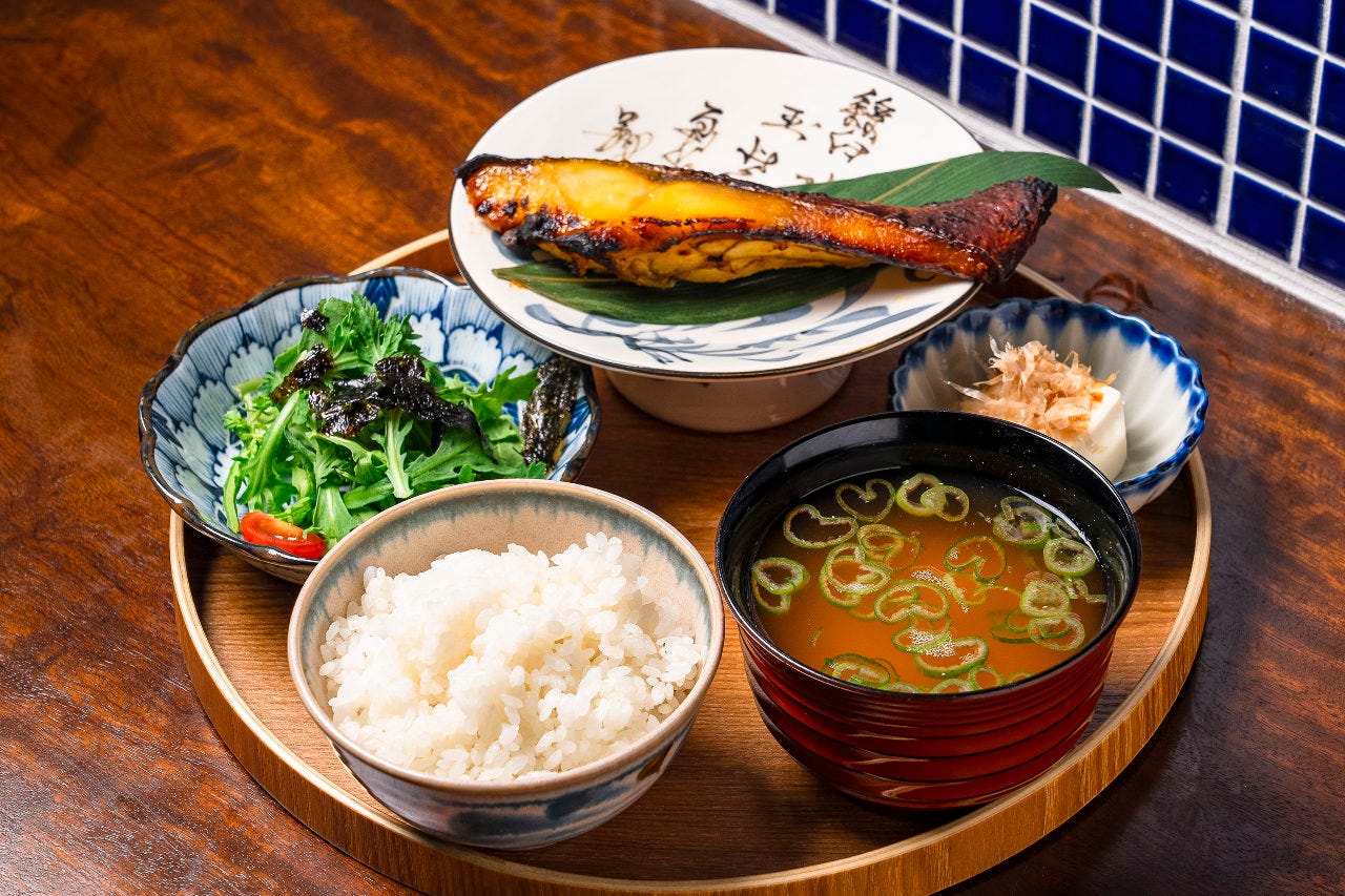 木のお盆にのったご飯と味噌汁とサラダと魚の西京味噌焼き
