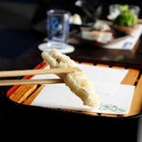揚げたての天ぷらを丁寧にお皿に盛りつけます