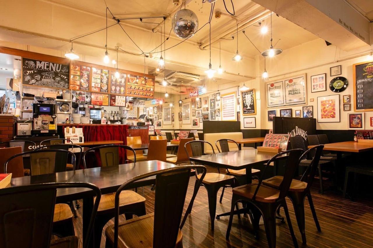 チャコールブラウンのテーブル席が並ぶカジュアルな店内