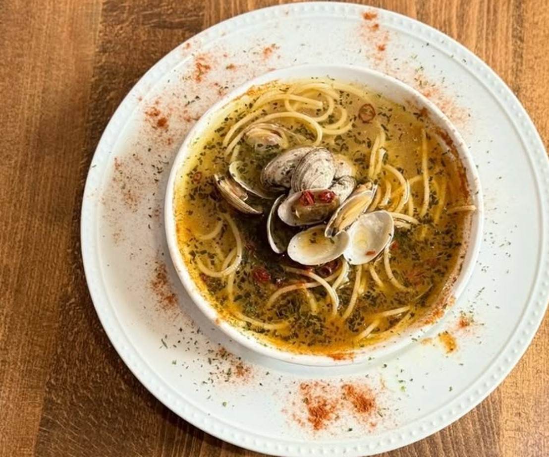 GOKAIアサリのペペロンチーノスープスパゲッティがベージュのテーブルにのった様子
