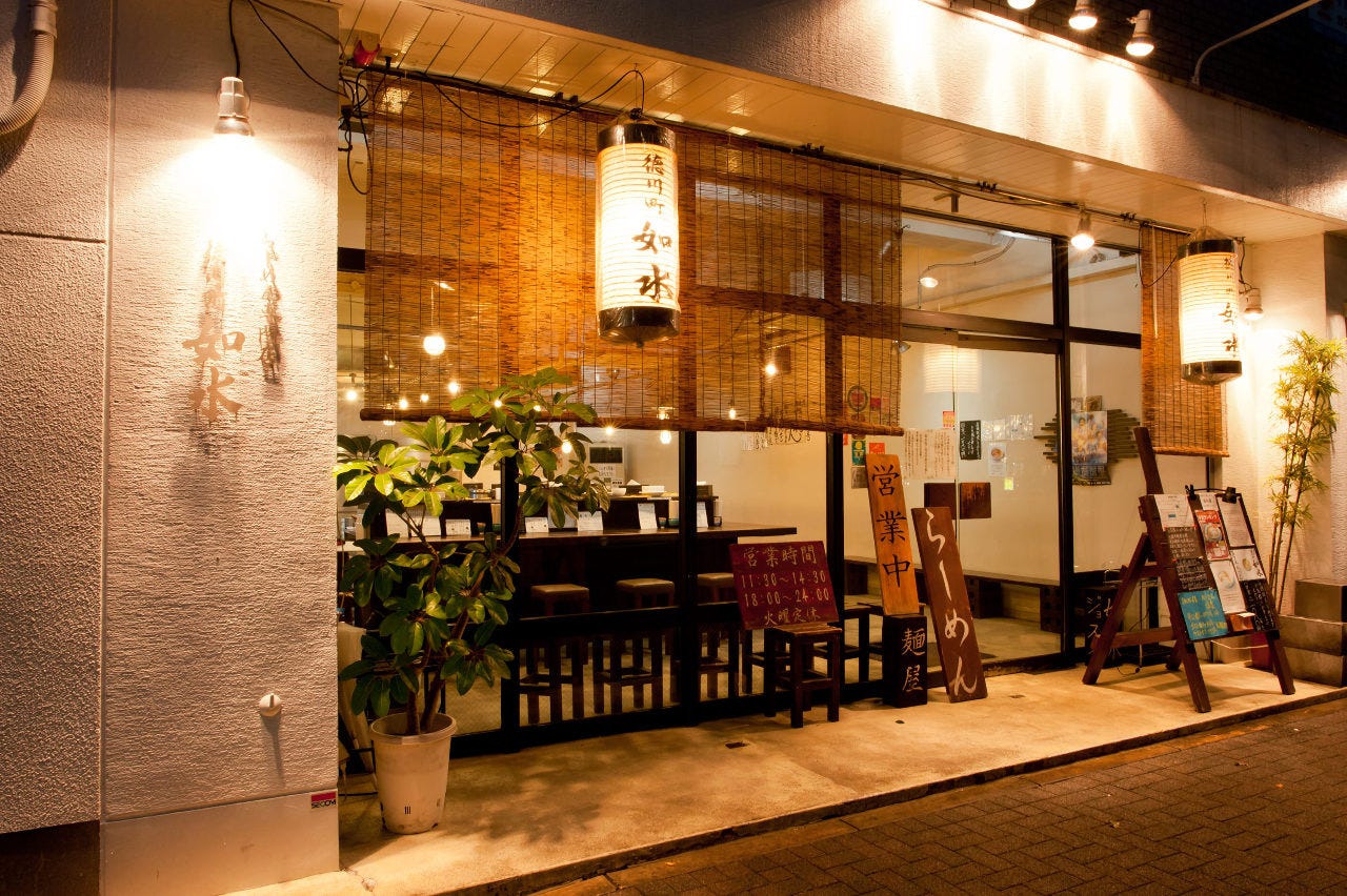 提灯やすだれがかかったガラス張りの徳川町 如水の外観